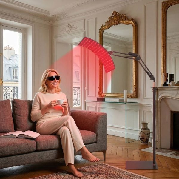 Femme détendue sur un canapé profitant d'une séance de lumière rouge et infrarouge.