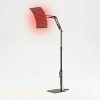 Lampe de luminothérapie sur pied articulé noir avec panneau LED incurvé allumé en rouge, utilisant la technologie de lumière rouge et infrarouge pour le soin à domicile